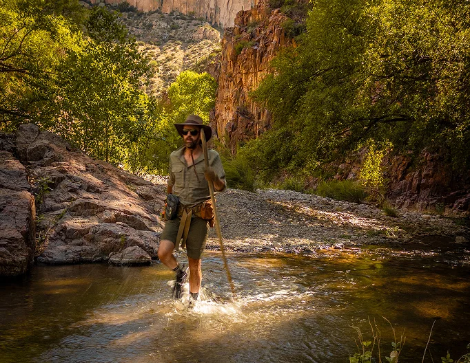 Guide walking through shallow water in Aravaipa Creek